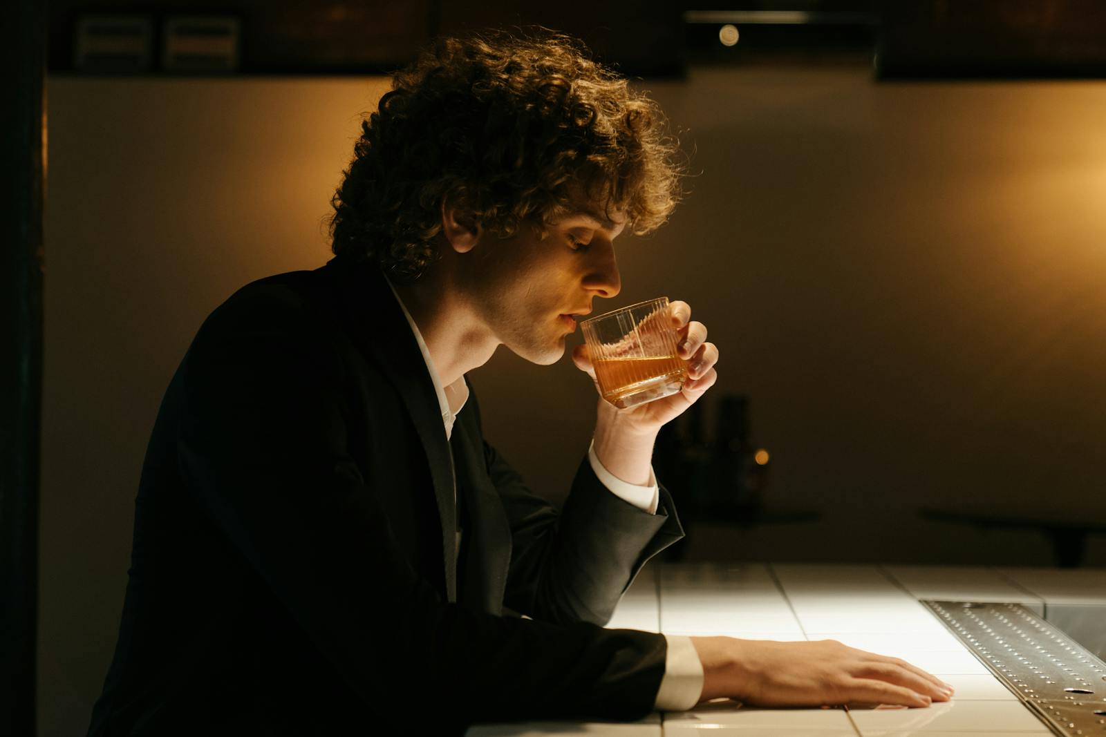 Man in Black Suit Drinking Beer